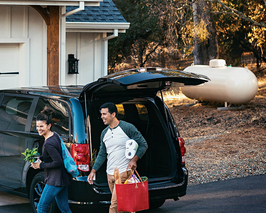 Couple unloading car next to propane tank