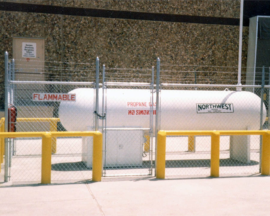 propane tank inside fence with crash posts