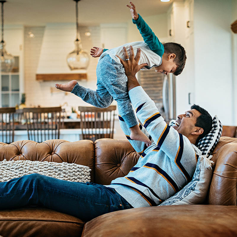 father playfully lifting his son into the air