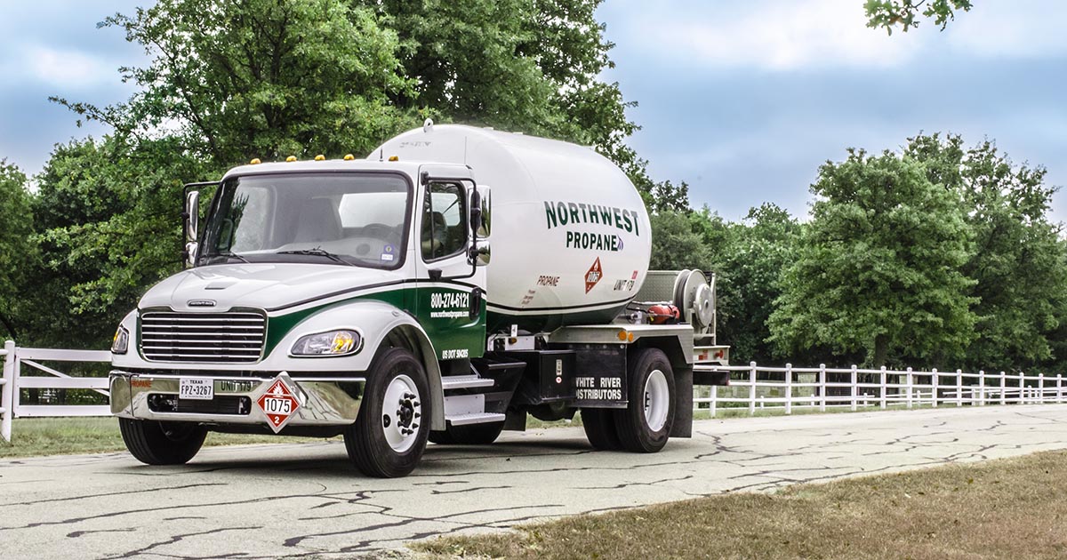 Northwest Propane delivery truck next to white fence