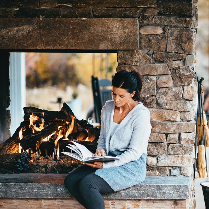 woman next to outdoor propane fireplace